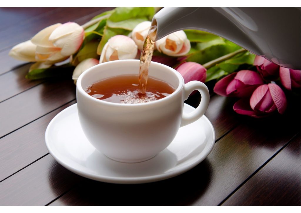 Tea being poured from pot into cup